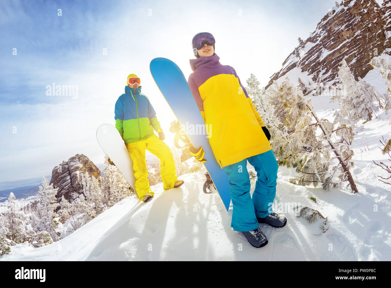 Two snowboarders male and female stands at offpiste ski slope with snowboards in hands Stock Photo