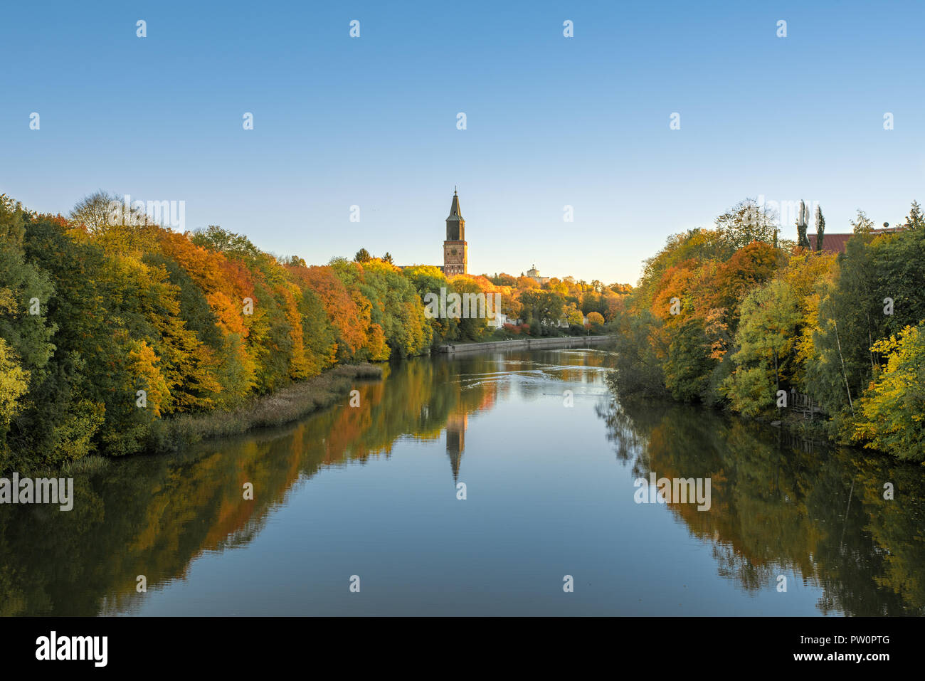 Beautiful fall foliage and Aura river against clear blue sky with Turku Cathedral in background in Turku, Finland, Autumn 2018 Stock Photo