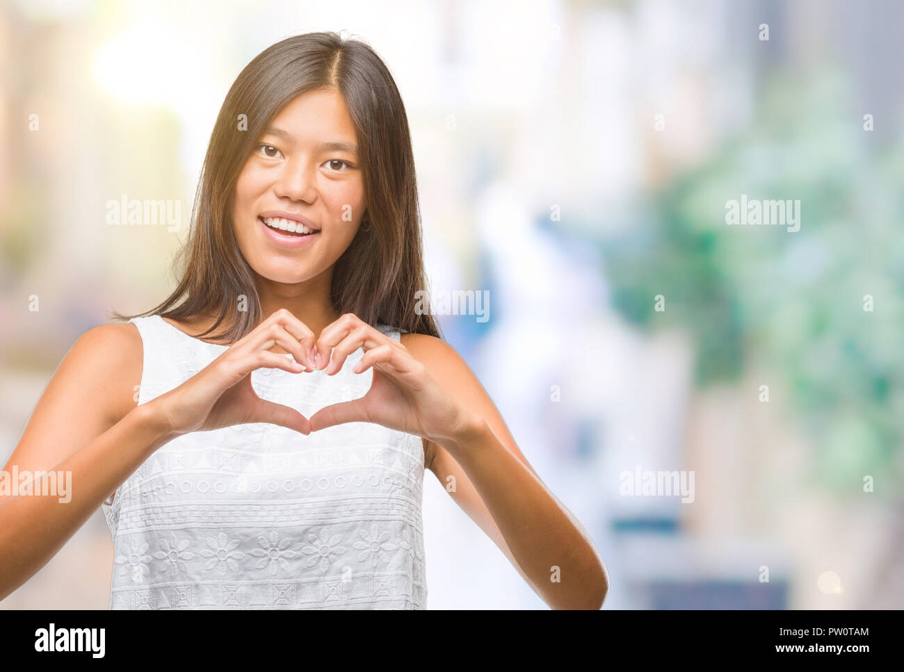 Young asian woman over isolated background smiling in love showing ...