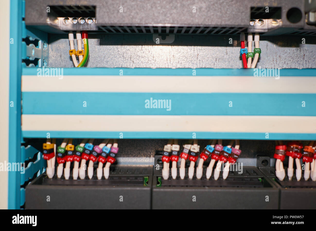 Black controller with connected colored numbered wires. Industrial background. Stock Photo