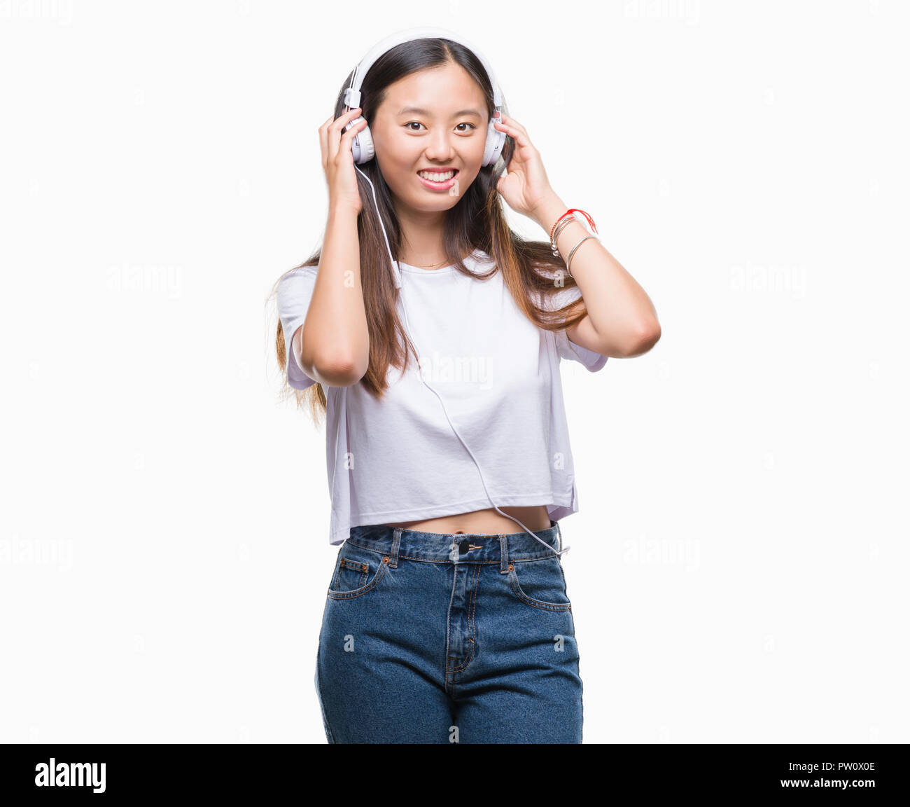 Young asian woman listening to music wearing headphones isolated ...