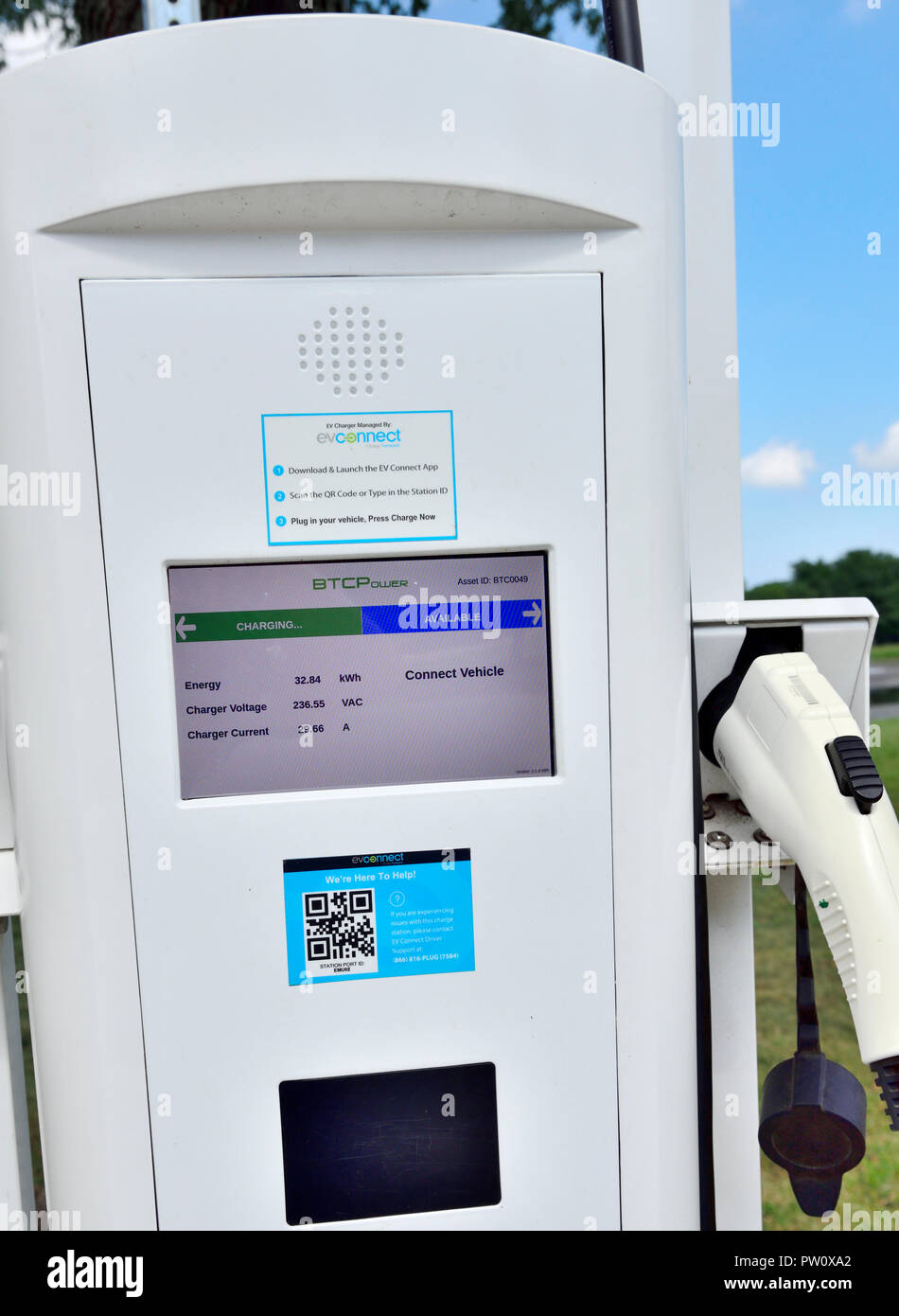 Public electric vehicle charging station with one car being charged