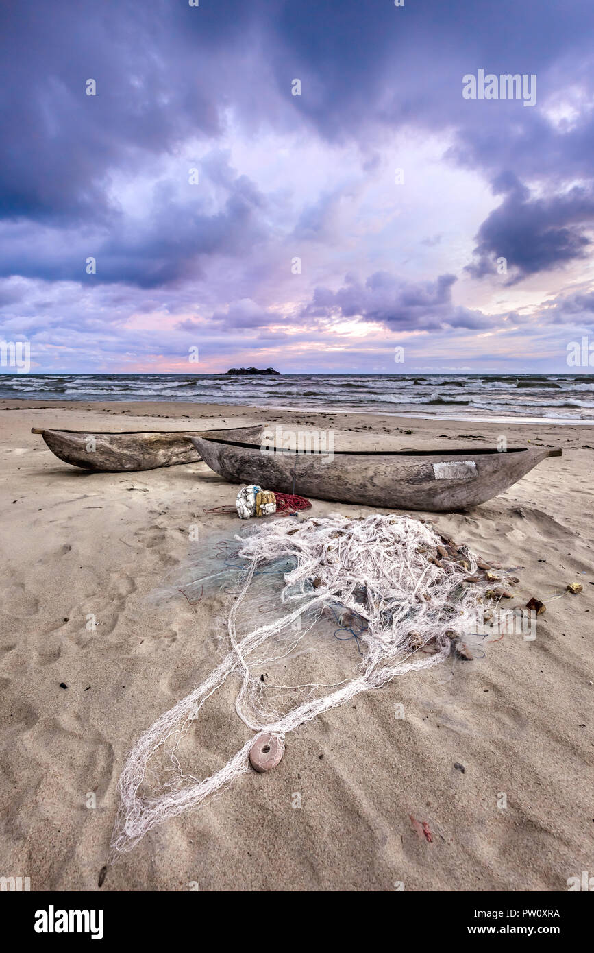 Boat and fishing net in the sand of the beach during storm sunset on lake Malawi Kande Beach in Africa, fisherman fish net Stock Photo