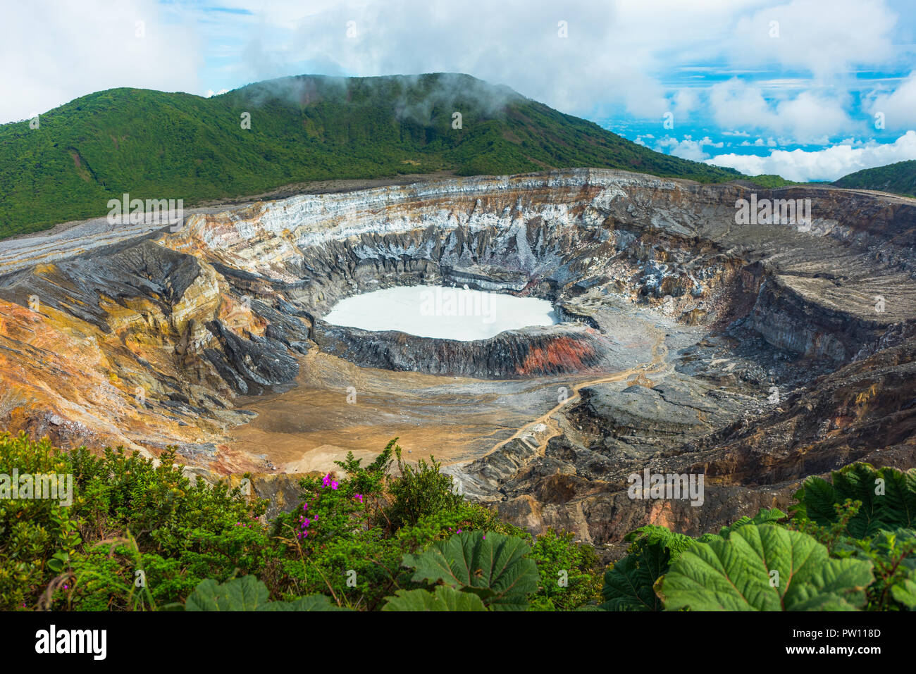 Poas Volcano in Costa Rica near San Jose. Beautiful white lagoon in an active volcano with a blue cloudy sky Stock Photo