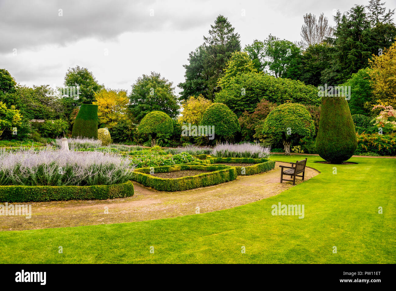 Flower beds and a bench in outdoor gardens at Crathes Castle estate near Banchory, Scotland Stock Photo