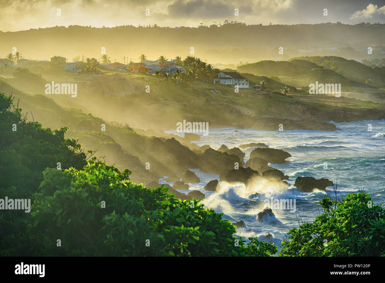Water spray hitting the land after strong waves splash on the rock, sunset at Ragged point in Eastern-Barbados Stock Photo