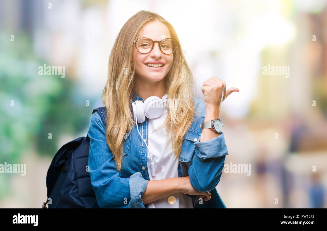 Young beautiful blonde student woman wearing headphones and glasses ...