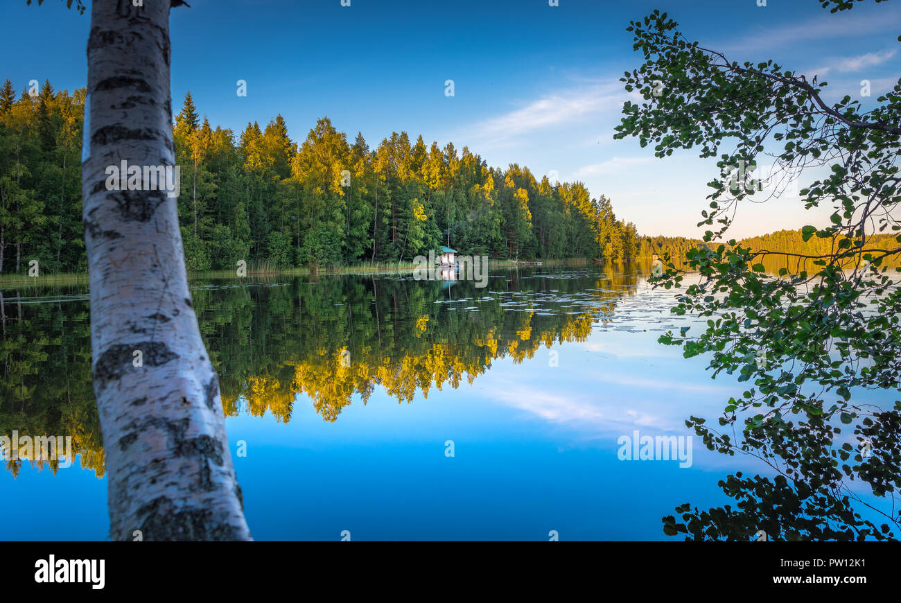 Lake in Tampere Finland, lake reflections on water with little house on the water, beautiful sky with many colors and trees Stock Photo
