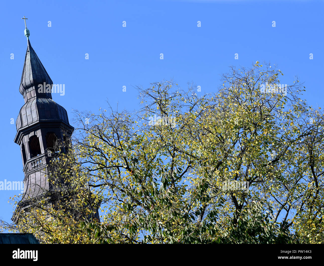Hanover, Lower Saxony. 11th Oct, 2018. The tower of the Protestant-Lutheran Neustädter Hof- und Stadtkirche St. Johannis in the Hanoverian district of Calenberger Neustadt stands next to an autumnal deciduous tree. Credit: Holger Hollemann/dpa/Alamy Live News Stock Photo