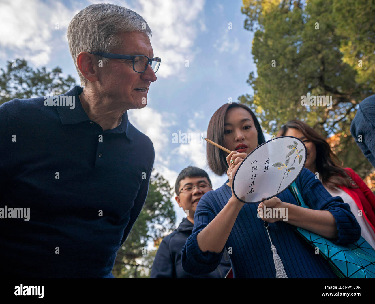 Beijing, China. 10th Oct, 2018. Apple's CEO Tim Cook looks at a woman writing calligraphy on a fan at Beijing Confucian Temple in Beijing, capital of China, on Oct. 10, 2018. Cook paid a visit to Beijing Confucian Temple and the Imperial College on Wednesday. Credit: Cai Yang/Xinhua/Alamy Live News Stock Photo