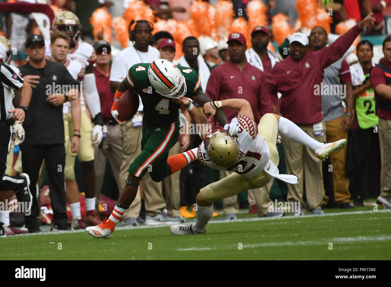 Miami Gardens, Florida, USA. 6th Oct, 2018. Jeff Thomas #4 of Miami is tackled by Logan Tyler #21 of Florida State during the NCAA football game between the Miami Hurricanes and the Florida State Seminoles in Miami Gardens, Florida. The Hurricanes defeated the Seminoles 28-27. Credit: csm/Alamy Live News Stock Photo
