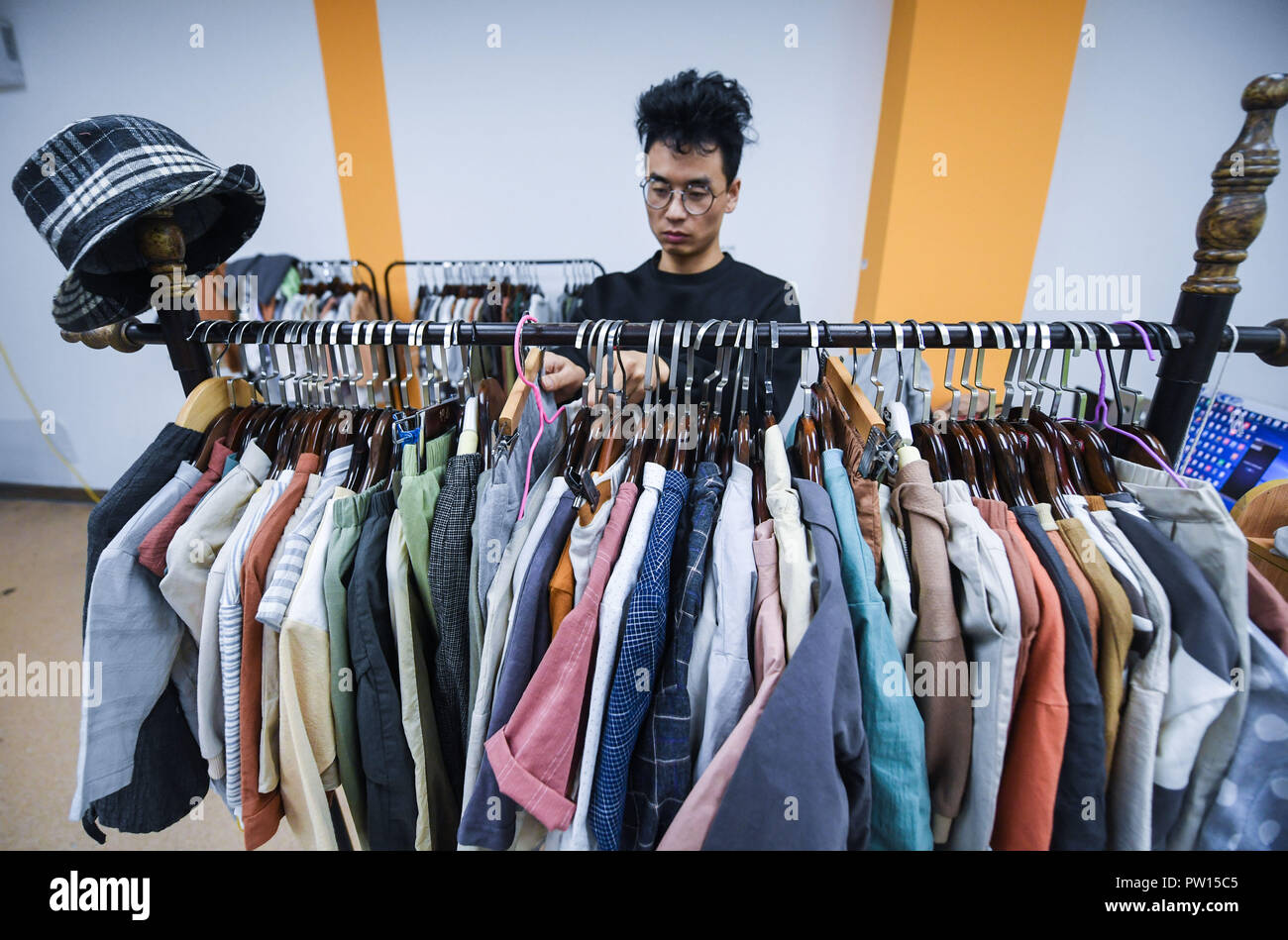 181011 HUZHOU Oct. 11 2018 Xinhua A fashion designer looks at various children s clothing designs at a children s clothing design center in Zhili Town of Huzhou east China s Zhejiang Province