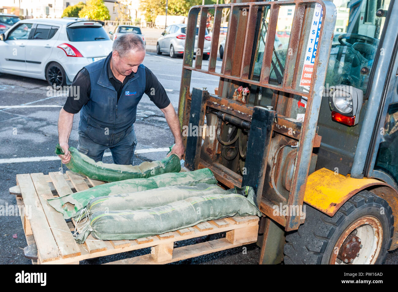 Bantry, West Cork, Ireland. 11th Oct, 2018. A member of Drinagh Hardware Store staff places sandbags outside the Drinagh store in preparation for the predicted Storm Callum, which is due to hit Ireland this evening. Credit: Andy Gibson/Alamy Live News. Stock Photo