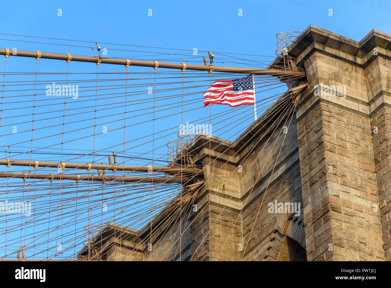 10-2018 Brooklyn, New York. The United States of America flag flies from the Brooklyn Bridge. Photo: © Simon Grosset Stock Photo