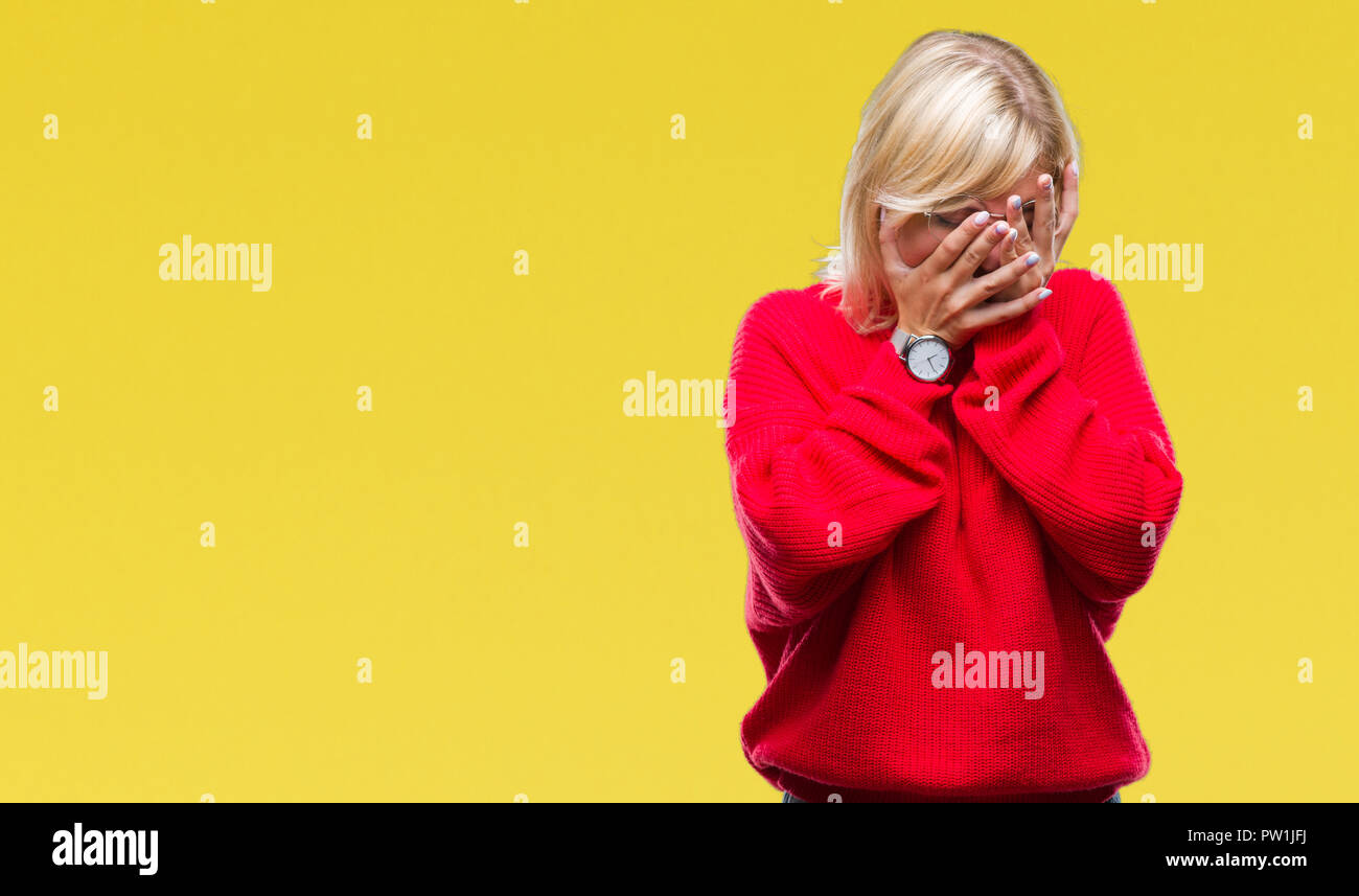 Young beautiful blonde woman wearing sweater and glasses over isolated background with sad expression covering face with hands while crying. Depressio Stock Photo