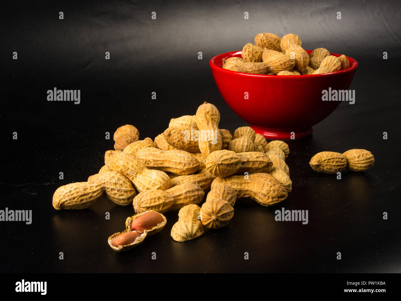 Peanuts, Arachis hypogaea, in shell on dark background, close up, selective focus Stock Photo