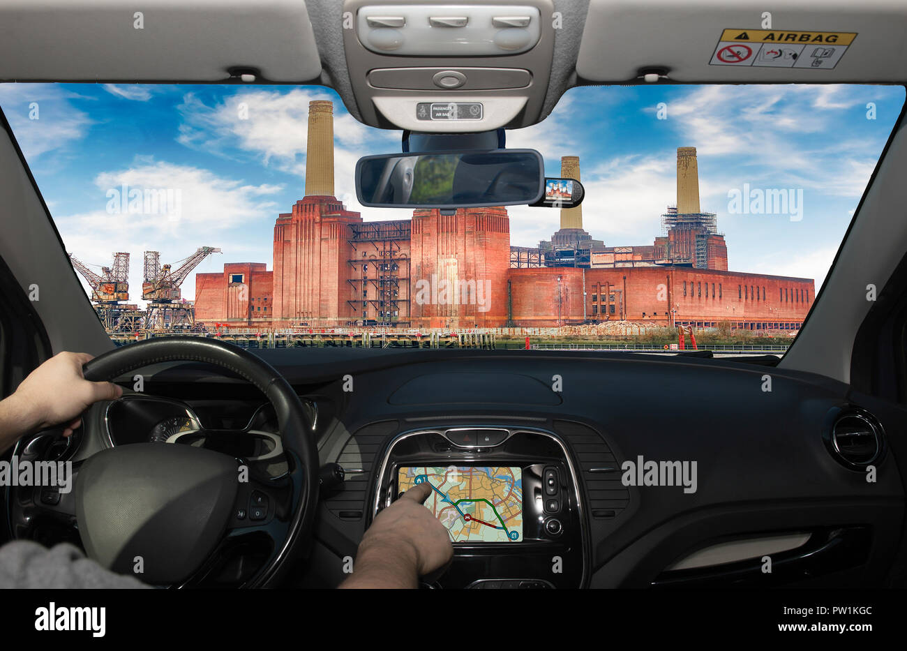 Driving a car while using the touch screen of a GPS navigation system towards Battersea Power Station, London, UK Stock Photo