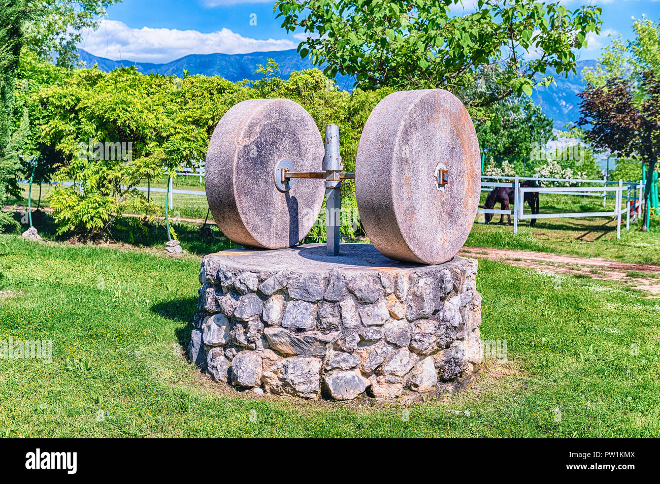 Ancient olive press with two millstones in the countryside Stock Photo