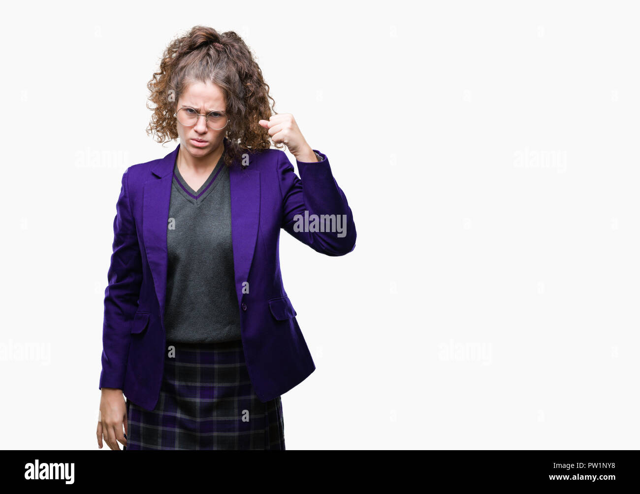 Young brunette student girl wearing school uniform and glasses over isolated background angry and mad raising fist frustrated and furious while shouti Stock Photo