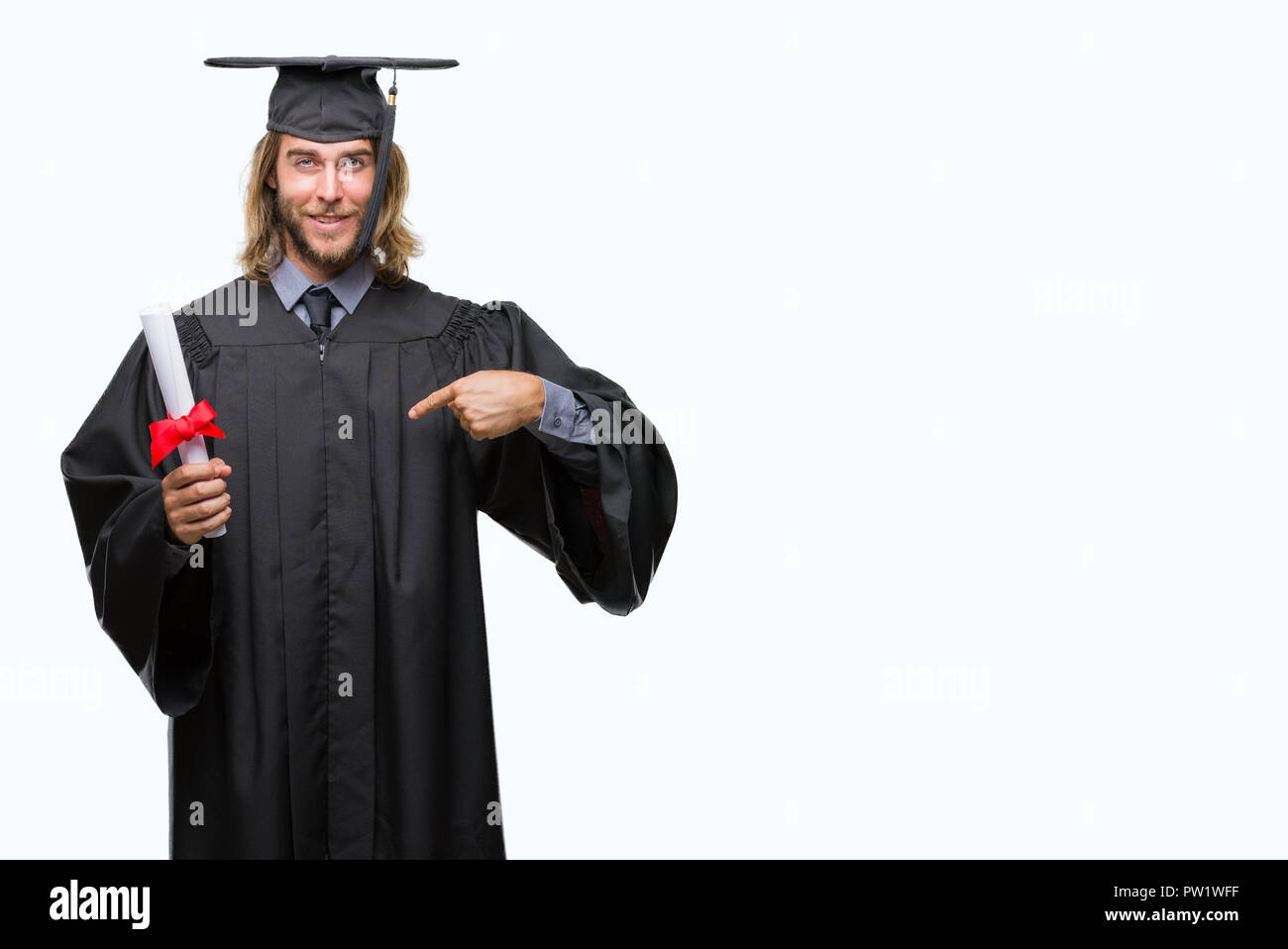 Young handsome graduate man with long hair holding degree over isolated ...