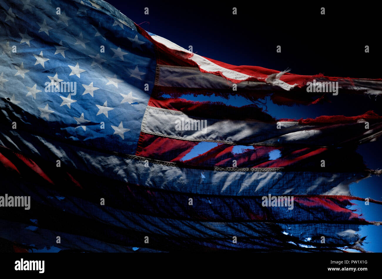 Relic Tattered American Flag, Ripped, Vintage, Discolored, Dramatic Lighting, Stars and Stripes Stock Photo