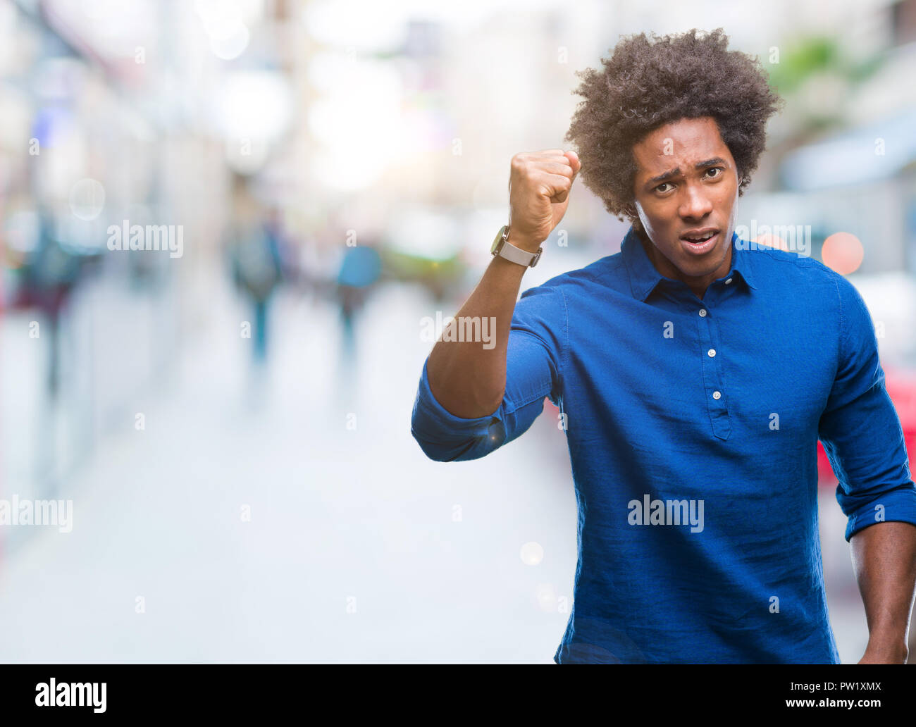 Afro american man over isolated background angry and mad raising fist ...