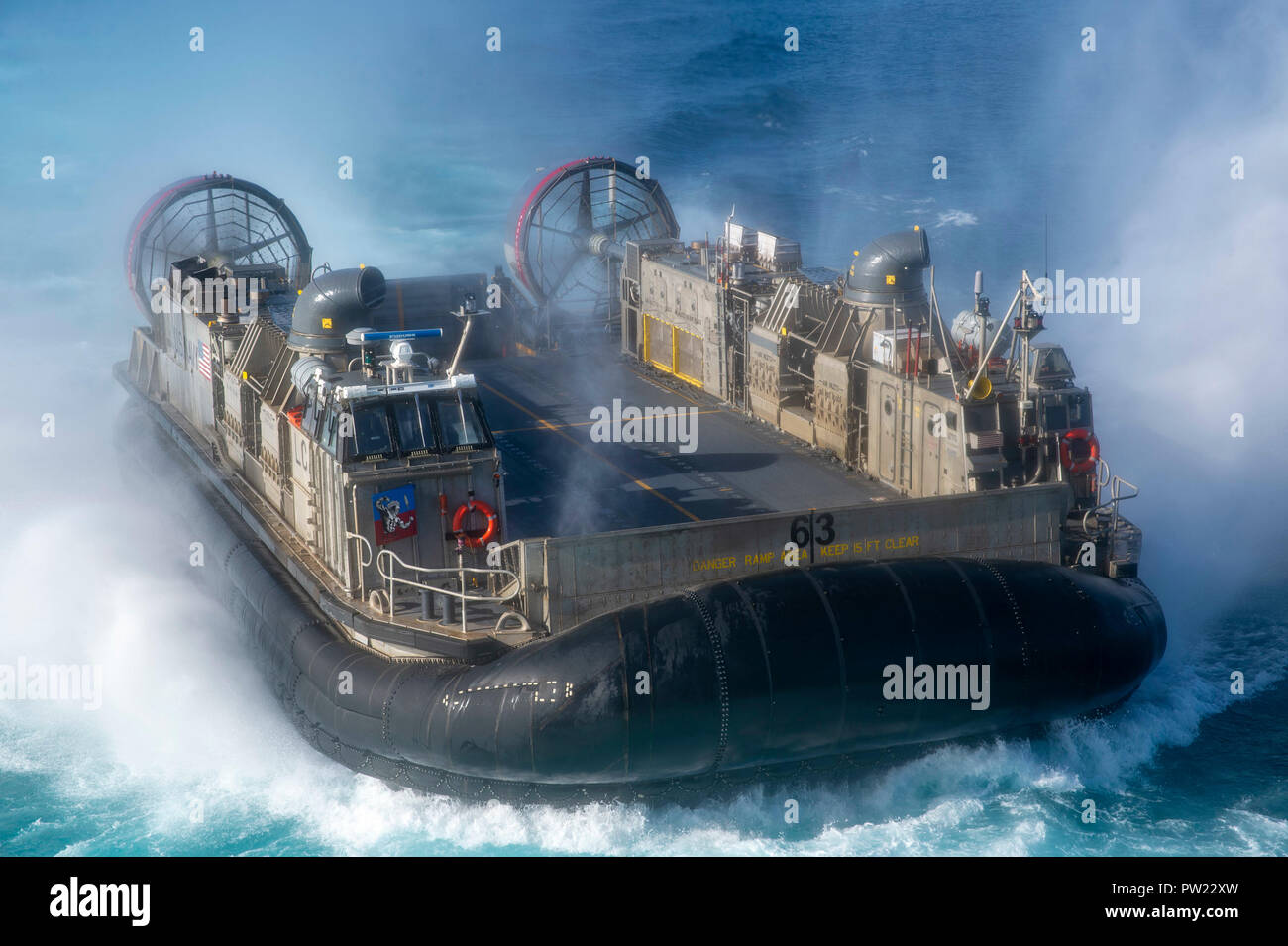 181010-N-DC385-1112 PACIFIC OCEAN (Oct. 10, 2018) Landing craft air cushion (LCAC) 63, assigned to Assault Craft Unit (ACU) 5, approaches the well deck of the amphibious assault ship USS Bonhomme Richard (LHD 6). Bonhomme Richard is operating in the U.S. 3rd Fleet area of operations. (U.S. Navy photo by Mass Communication Specialist 3rd Class Cosmo Walrath) Stock Photo
