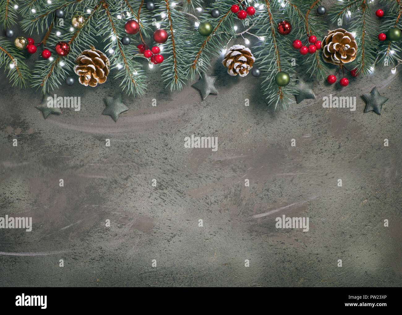 Christmas background with fir twigs, red berries, cones and Xmas lights ...