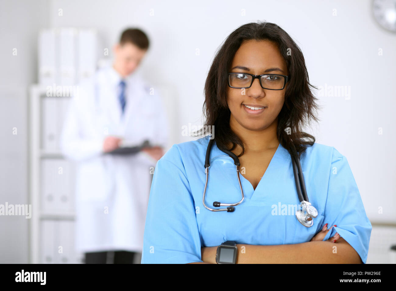 Female african american medical doctor with colleagues in background at
