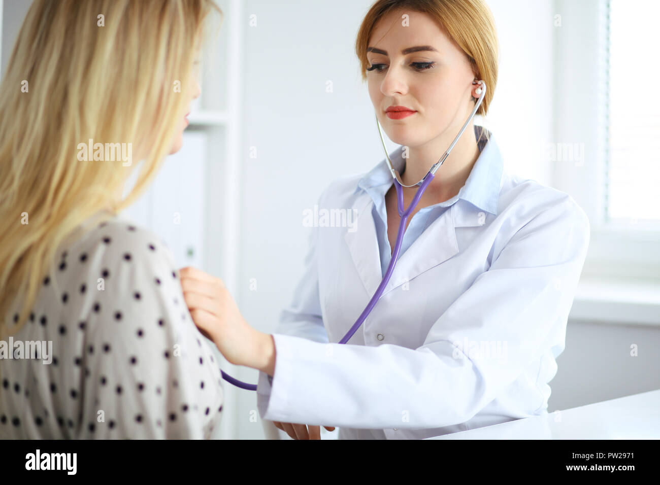 Doctor examines a patient with a stethoscope Stock Photo - Alamy