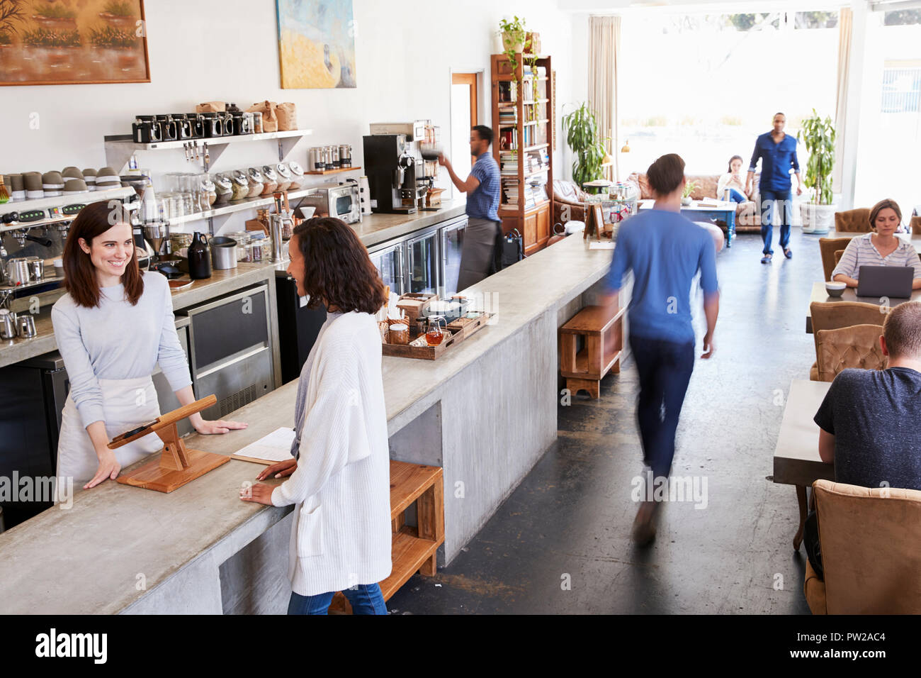 Customer at a counter of a busy coffee shop, elevated view Stock Photo