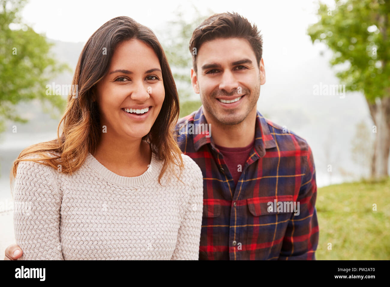 Young smiling couple sitting a park, portrait Stock Photo
