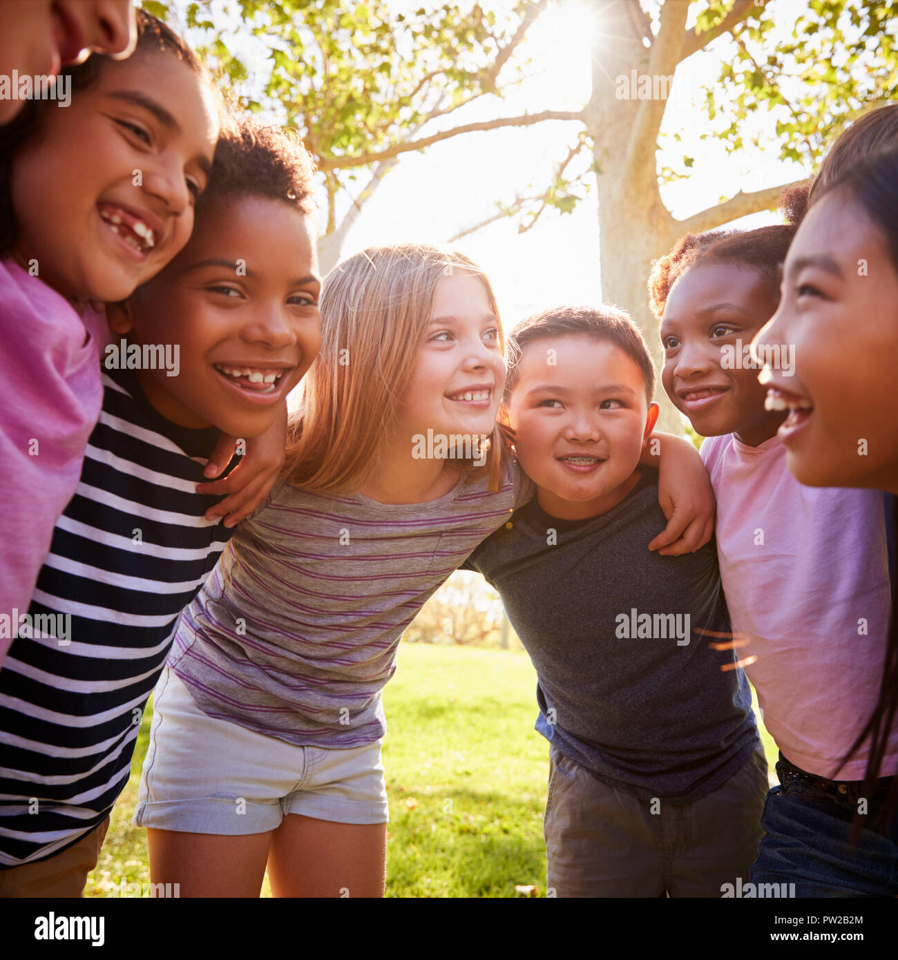 School kids embrace standing in a circle, square format Stock Photo