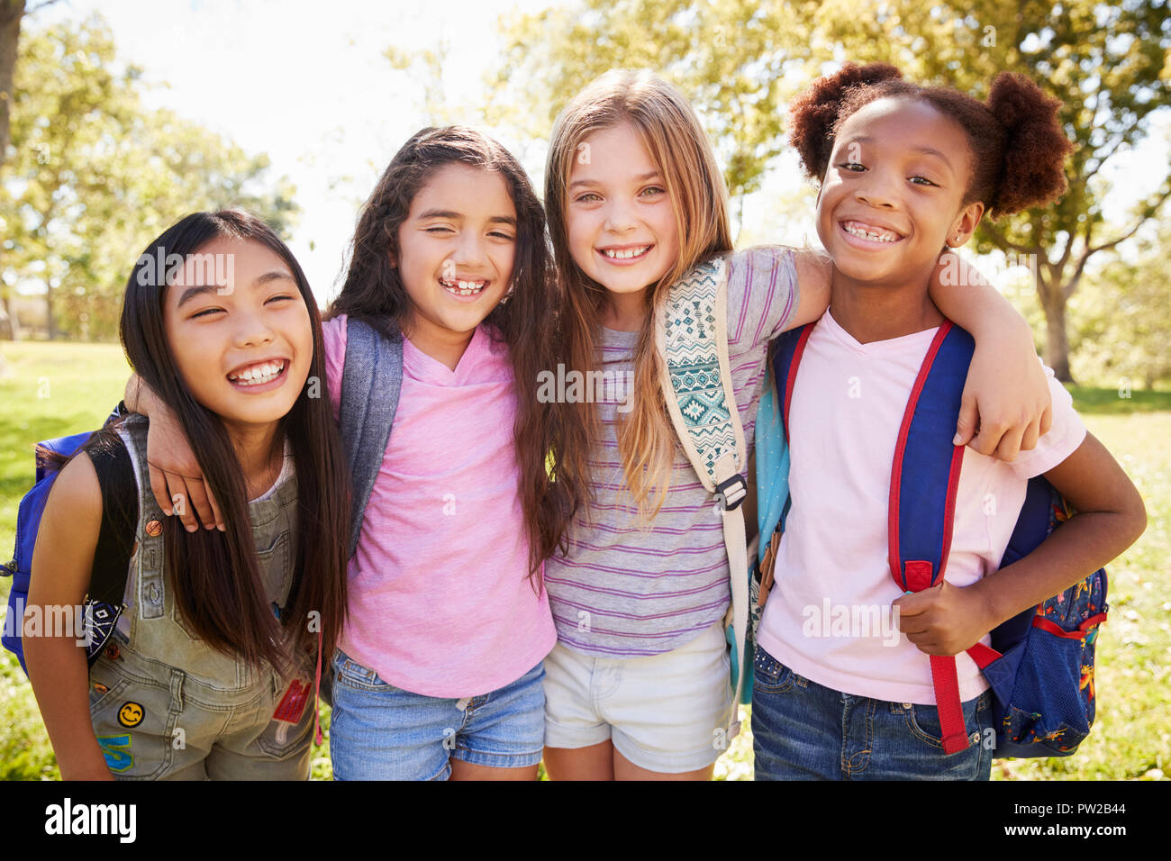 Four young smiling schoolgirls on a school trip Stock Photo
