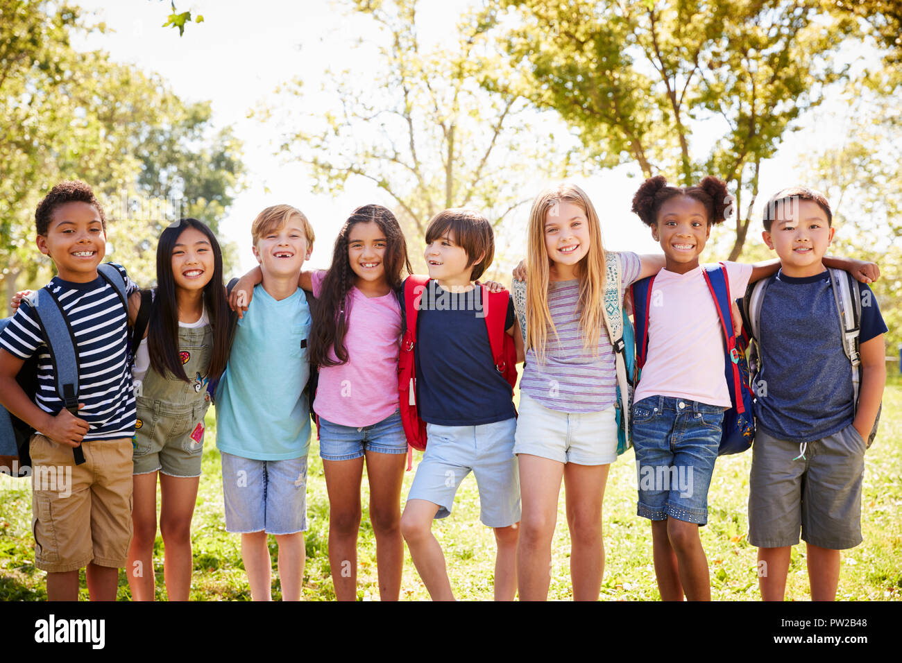 Group of schoolchildren stand embracing in a row outdoors Stock Photo ...