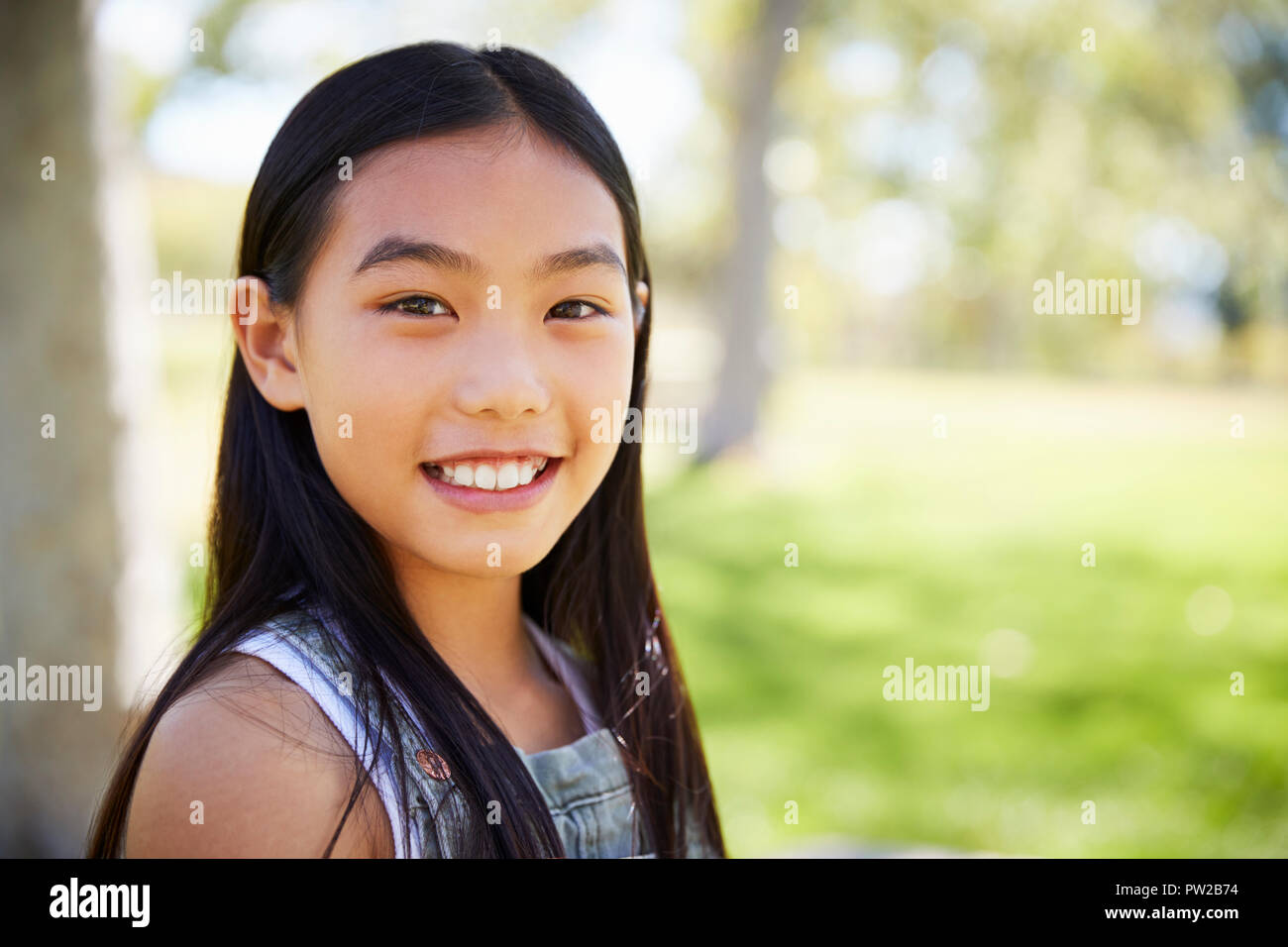 Young Asian schoolgirl smiling to camera, close up Stock Photo