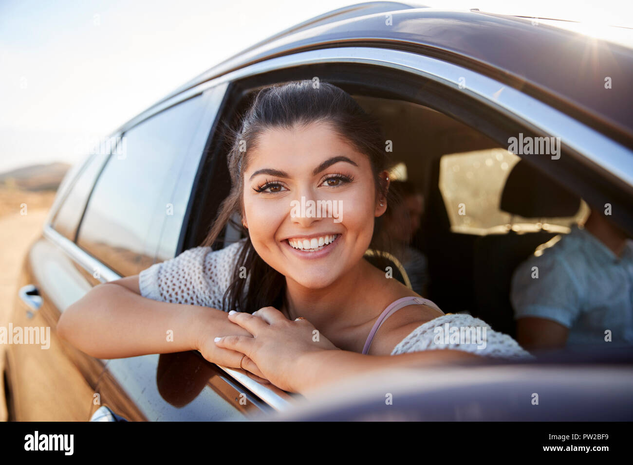 Portrait Of Smiling Woman Looking Out Of Car Window Enjoying Road Trip ...