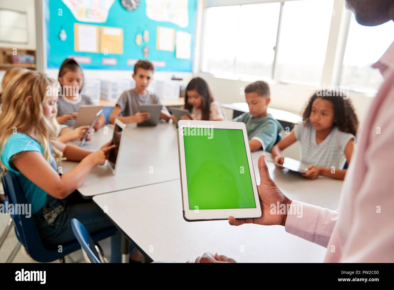 Teacher and kids using tablets in elementary school lesson Stock Photo
