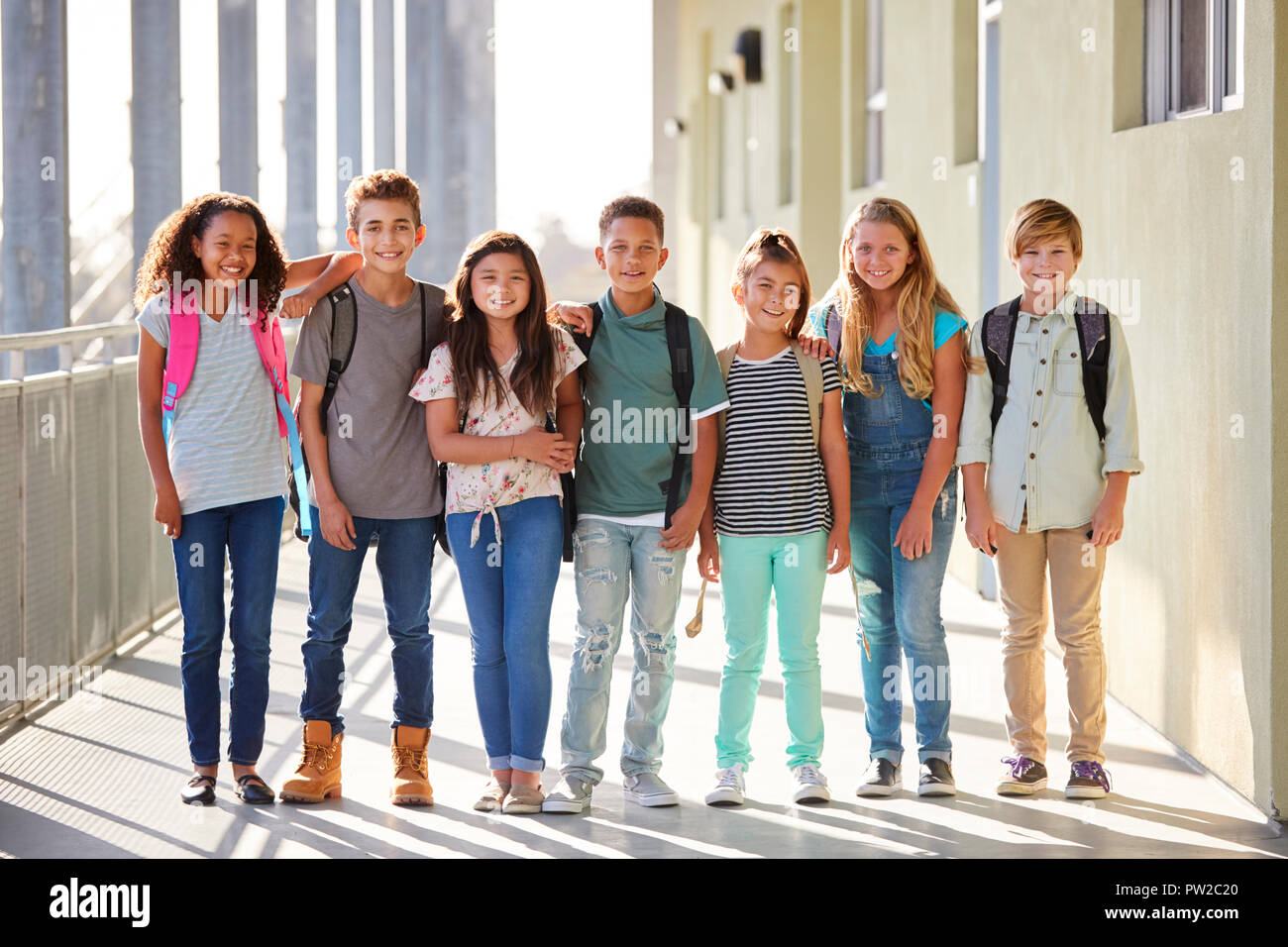 Elementary school kids stand in corridor looking at camera Stock Photo