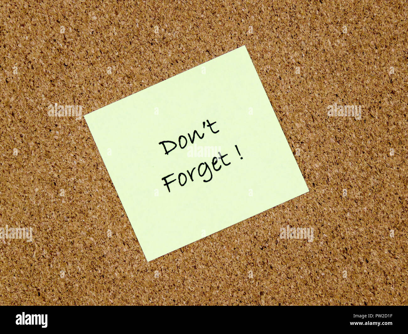 A yellow sticky note with don't forget written on it on a cork board background Stock Photo