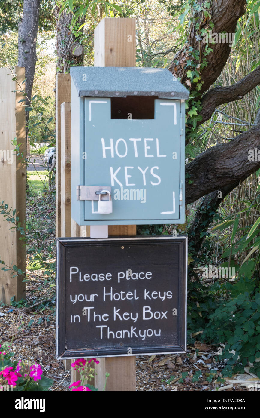 Key box for returning hotel keys placed outside on a post Stock Photo