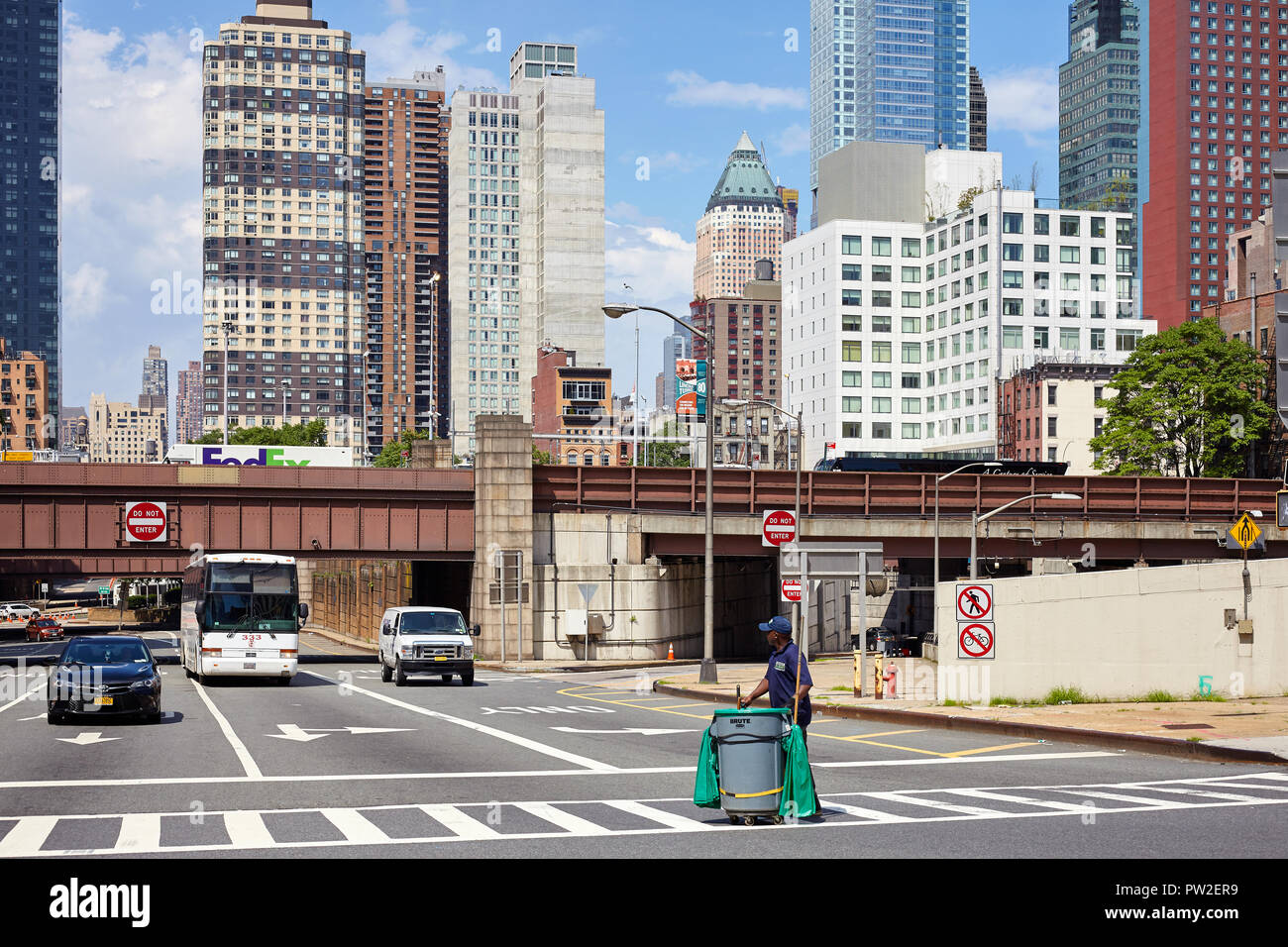New York, USA - June 28, 2018: Maintenance worker walks across a zebra crossing. Stock Photo