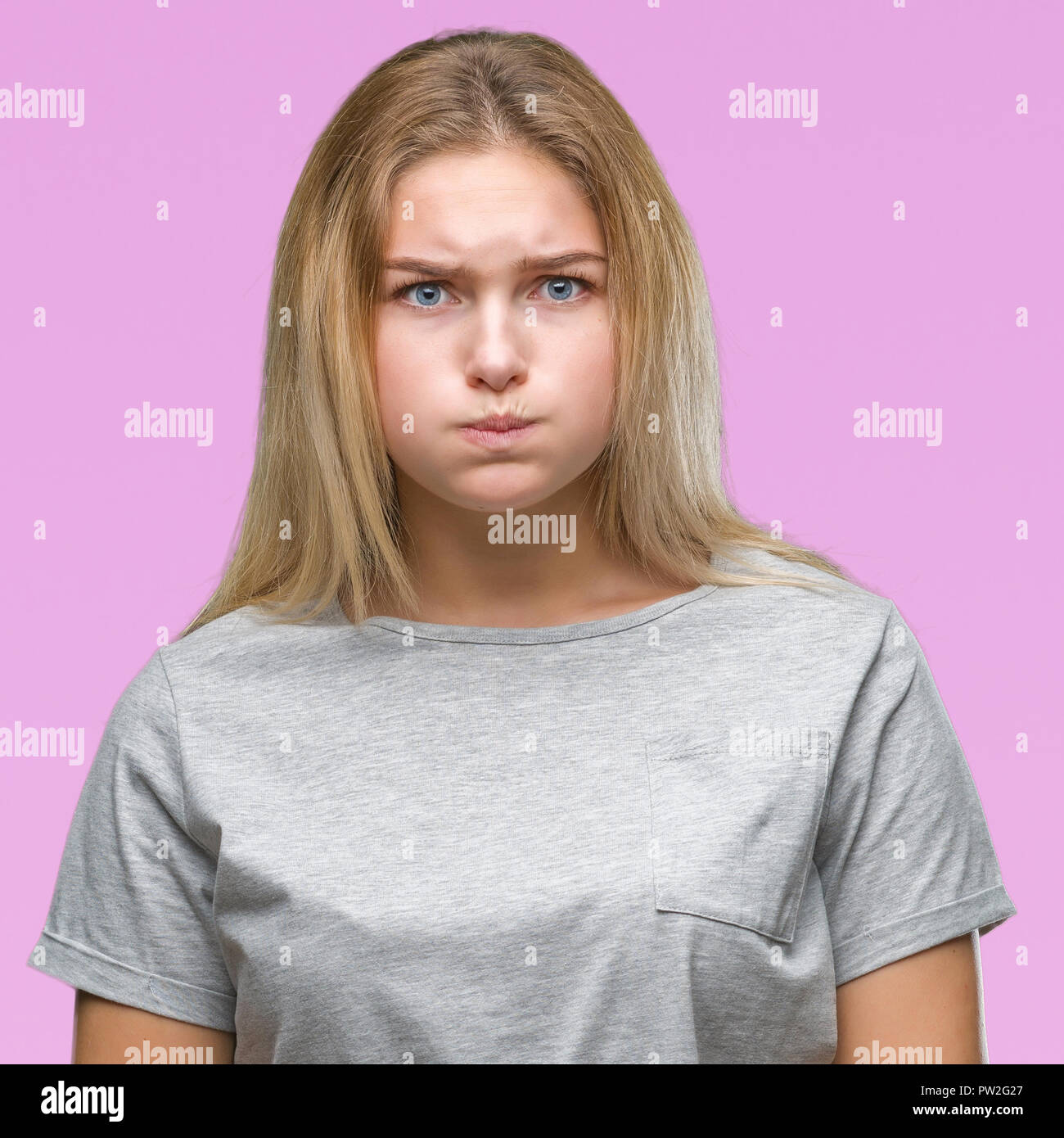 Young caucasian woman over isolated background puffing cheeks with