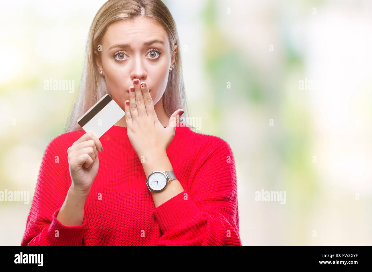 Young blonde woman holding credit card over isolated background cover ...