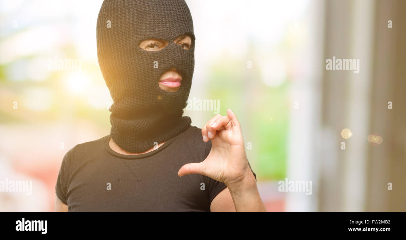 Burglar terrorist woman wearing balaclava ski mask proud, excited and  arrogant, pointing with victory face Stock Photo - Alamy