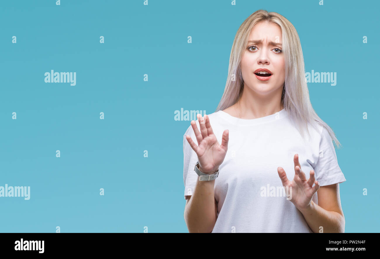 Young blonde woman over isolated background afraid and terrified with fear expression stop gesture with hands, shouting in shock. Panic concept. Stock Photo