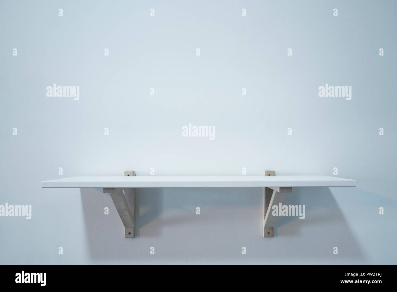 Empty wooden shelf on white wall Stock Photo