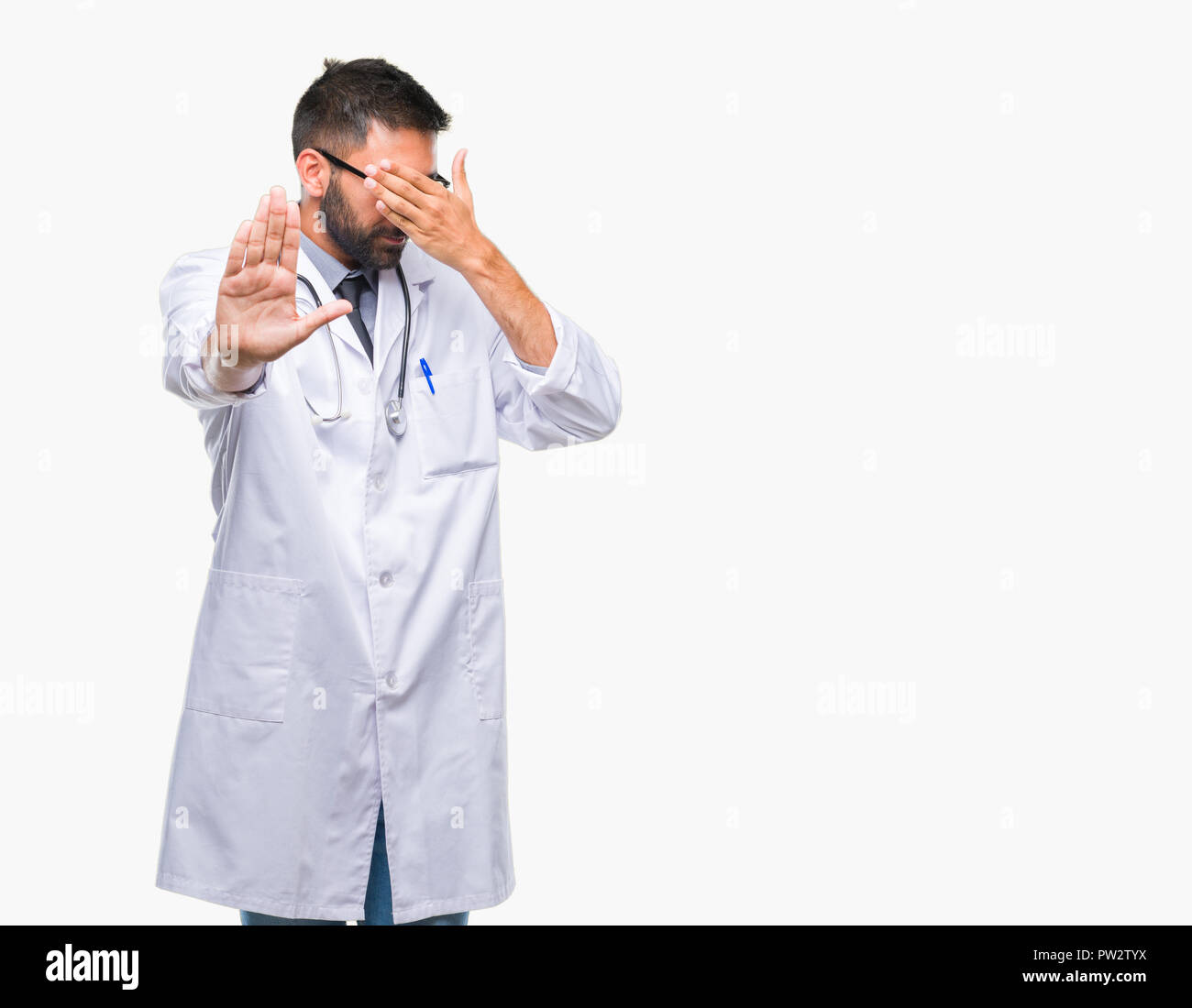 Adult hispanic doctor man over isolated background covering eyes with hands and doing stop gesture with sad and fear expression. Embarrassed and negat Stock Photo