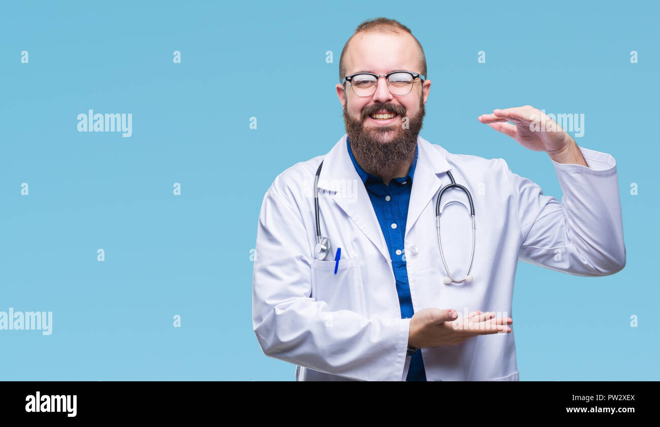 Young caucasian doctor man wearing medical white coat over isolated ...