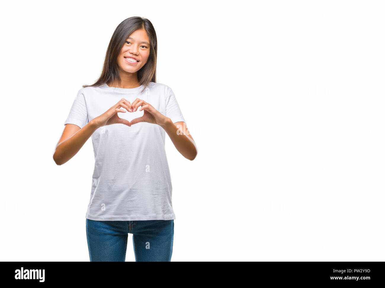 Young asian woman over isolated background smiling in love showing heart symbol and shape with hands. Romantic concept. Young asian woman over isolated background smiling in love showing ...